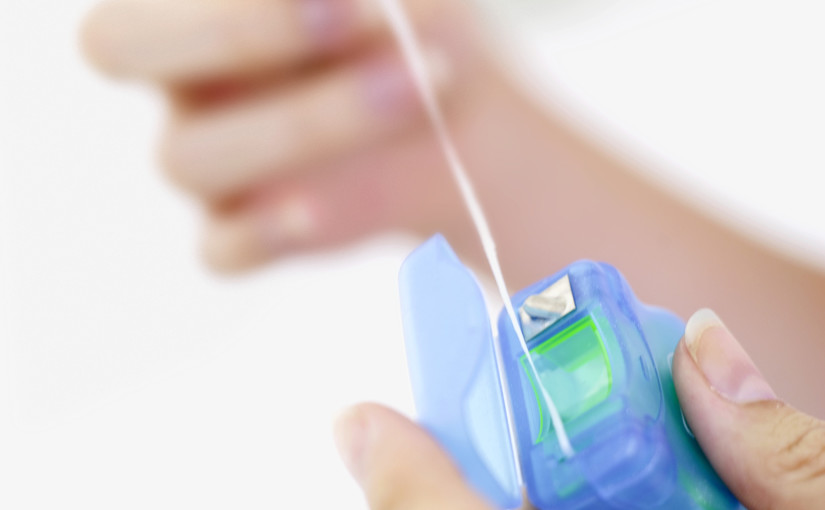 Close-up of a person's hand pulling out dental floss