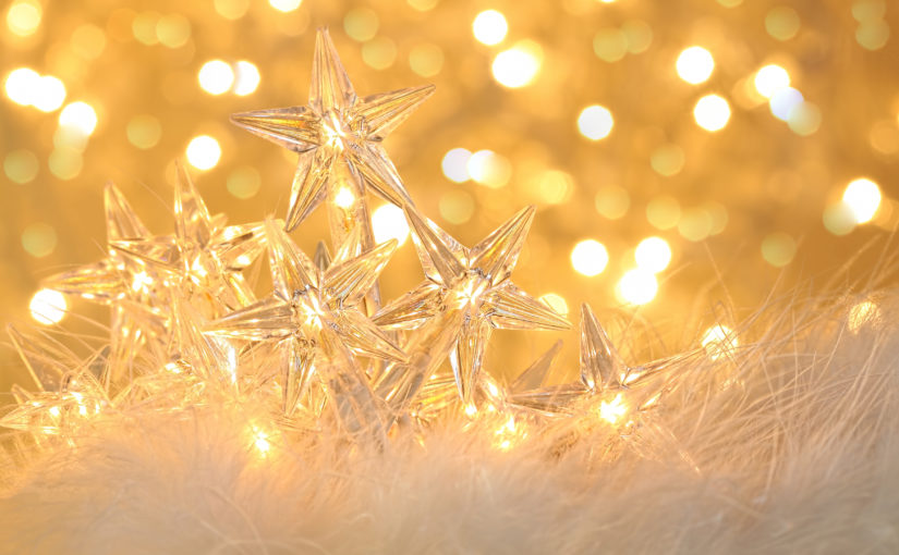 Star-shaped holiday lights against a golden sparkle background.
