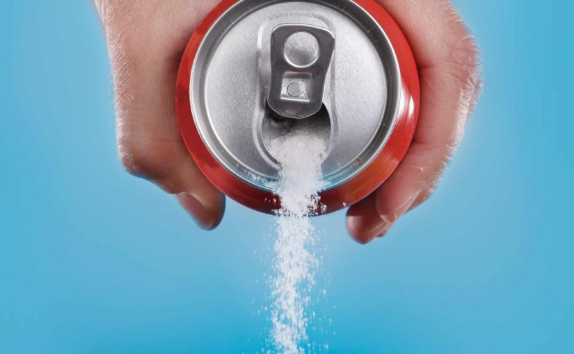 Hand pouring sugar out of an open can of soda pop.