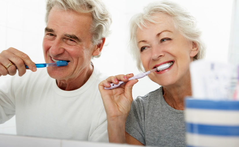 Smiling senior couple brushing their teeth.